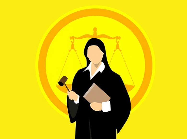 A judge in a robe with the balance of justice scales in the background
